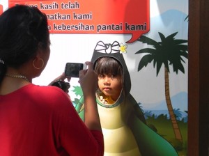 Kasih Sayang – Seorang anak kecil dengan wajah cemberut difoto oleh ibunya di Pantai Kuta, Sabtu (9/3/13). 