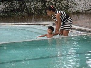 Pengawasan – Seorang balita sedang belajar berenang dengan pegawasan dari orang dewasa di Tiara Dewata, Minggu (26/1/13). 